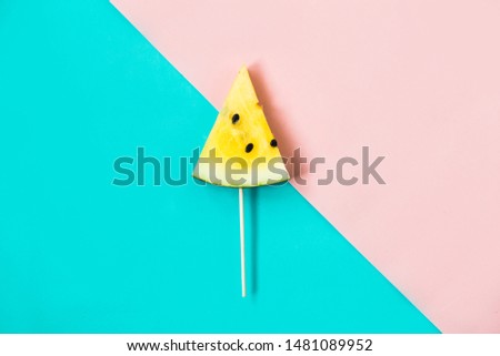 triangular ice cream slices on a stick of ripe yellow watermelon