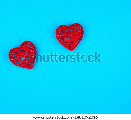 two red decorative hearts on a blue  background, copy space