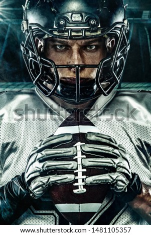 American football player. Sportsman with ball in helmet on stadium in action. Sport wallpaper. Team sports.