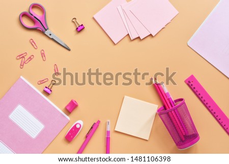 Flat lay pink stationery and school supplies on a pastel yellow background. Back to school. View from above, copy space
