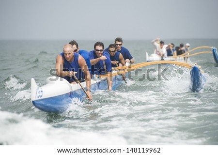 Crew of a racing outrigger canoe on water Royalty-Free Stock Photo #148119962