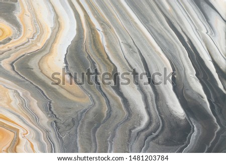 photography of abstract marbleized effect background. black, gray, gold and white creative colors.