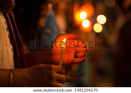 The candlelight that is illuminating and has a hand that prevents the wind from blowing out in the picture has noise.