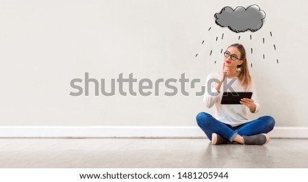 Rain cloud with young woman holding a tablet computer