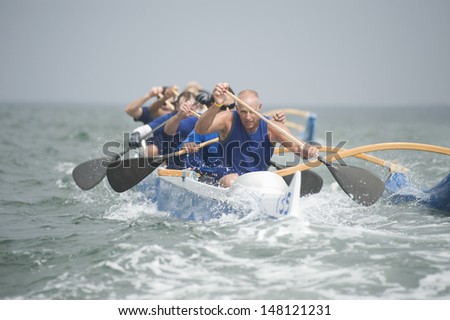 Crew of a racing outrigger canoe on water Royalty-Free Stock Photo #148121231