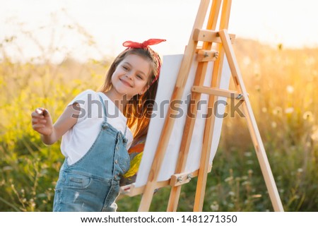 Little Girl Is Painting Picture Outdoors