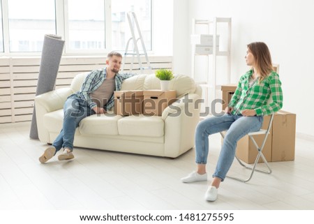 Positive smiling young girl sitting against her laughing in a new living room while moving to a new home. The concept of joy from the possibility of finding new housing.