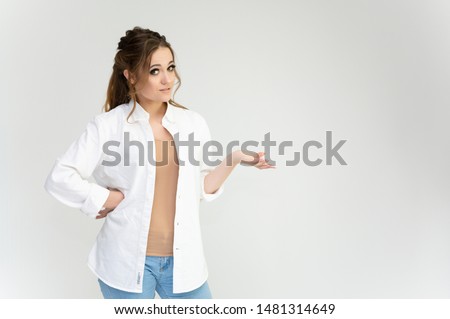 Photo waist-length portrait of a pretty brunette woman girl with long beautiful curly hair on a white background in a white shirt. Talking in different poses. Standing facing the camera.