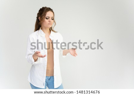 Photo waist-length portrait of a pretty brunette woman girl with long beautiful curly hair on a white background in a white shirt. Talking in different poses. Standing facing the camera.