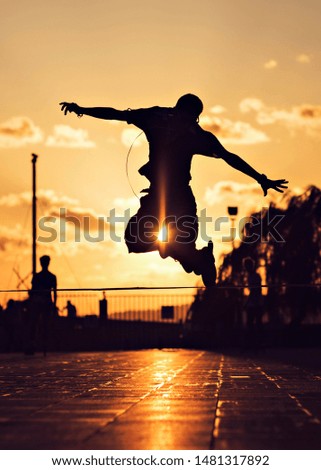 a group of teenage male model is having fun and acrobatic moves with their roller blades and skate boards at sunset time