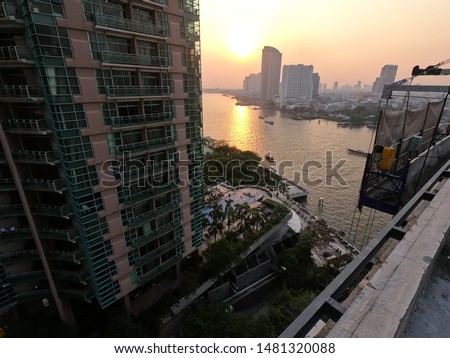 sunset at chao phraya river bangkok and biliding under construction