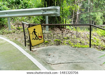 Man on Stairs going down sign symbol beside the street in the park background. Walk down sign with handrail in the garden