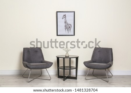 Room interior with modern chairs and table near light wall