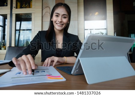 Business woman hand holding pen and pointing at financial paperwork with financial document.