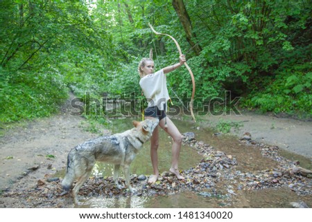 slim ethnic girl with her wolf dog in the deep forest alone
