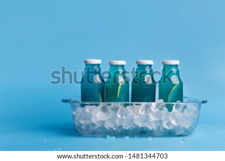 Isotonic drink. Set of summer blue detox water in ice for sale on background with copy space for advertisement