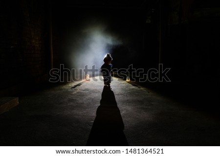 Horror scene of a scary children's ghost, Silhouette of scary baby doll on dark foggy background with light. Horror Halloween concept