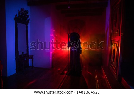 Horror silhouette of ghost inside dark room with mirror. Scary halloween concept. Silhouette of witch inside haunted house with fog and light on background. Selective focus