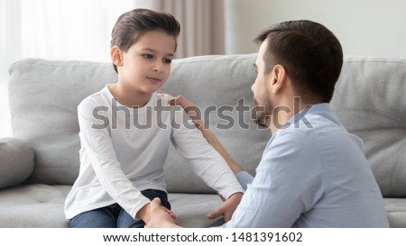 Father and little son having heart to heart talk at home, daddy try to help solve problems search solution together parent showing care and love or older brother ask forgiveness to younger boy concept Royalty-Free Stock Photo #1481391602