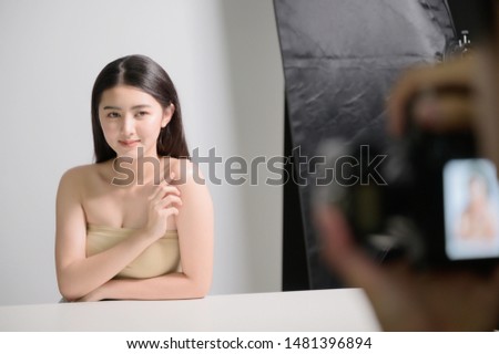 Photographer take a photo working with female model in studio