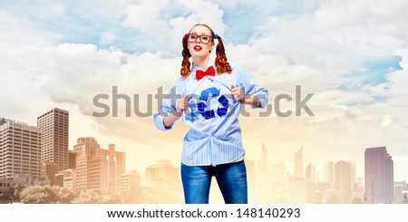Young woman acting like super hero with recycle sign on chest