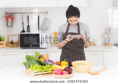 Asian young housewife, blogger taking food photo by smartphone to social online.