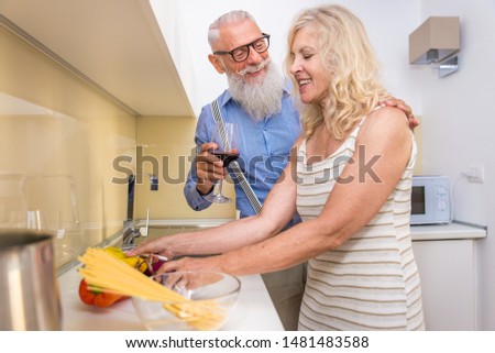 Senior couple cooking at home - Mature adults preparing dinner, concepts about senority and relationship