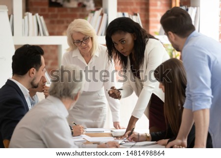 Multiracial focused employee gather in office brainstorm discussing startup plan project at meeting, diverse successful businesspeople cooperating consider share ideas collaborate at briefing Royalty-Free Stock Photo #1481498864
