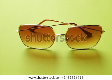 close up and top view sunglasses on a green background