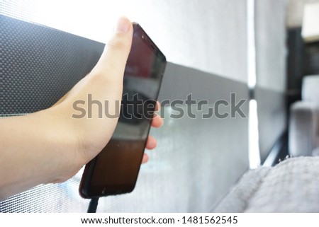 hand hold black phone for business calling with gray background
