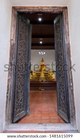 Beautiful old wooden door frame with Buddha sculpture in Wat Dhamma Racha temple Ayutthaya,Thailand