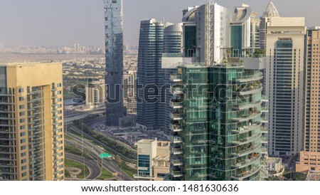 Aerial top view of Dubai Marina and JLT evening timelapse. Skyscrapers before sunset in Dubai, UAE. Modern towers and traffic on the road