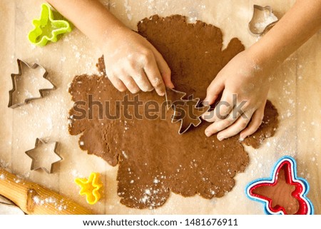 Faceless child preparing Christmas cookies
From above crop kid cutting out fir tree shape from dough while cooking ginger biscuits at home