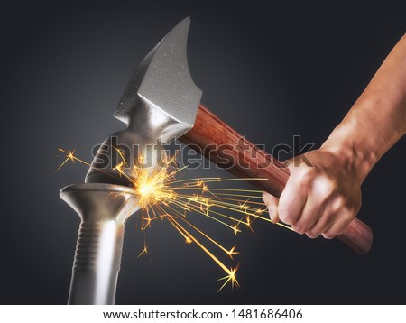 Man hammering a nail. Concept threats, dangers and power. Fighting two forces. A blow of such strength that sparks fly Royalty-Free Stock Photo #1481686406