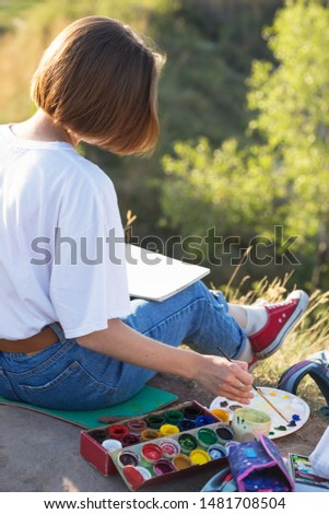 time of creativity. Painting En Plein Air. girl draws a landscape in nature
