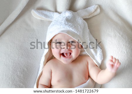 Adorable newborn baby wrap by white rabbit towel with smiling face. Happy mixed race Asian-German boy drying after bathing Royalty-Free Stock Photo #1481722679