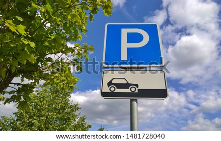 Road car parking sign on a sunny sky with clouds and trees background showing how to correctly place their vehicles. Concept of traffic rules and code. Parking fines.
