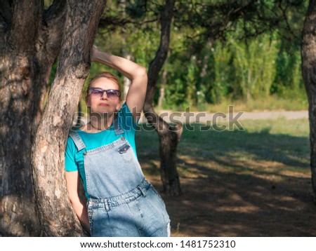 Portrait of the beautiful woman in the park. Photo of the woman. Green trees background. Woman on the nature. 
Full face
