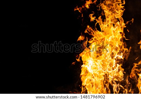 bright glowing flames on a black background on the right side of the picture