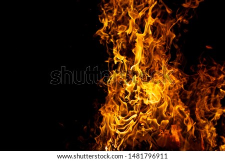 bright glowing flames on a black background on the right side of the picture
