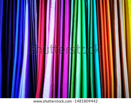 Multicolored satin fabric. Folded into thin strips of textile pieces for display in the store. Close-up photo