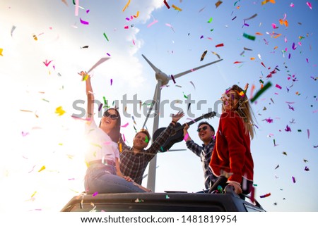 Best friends enjoying the outdoor party together with colorful papers in nature stock photo