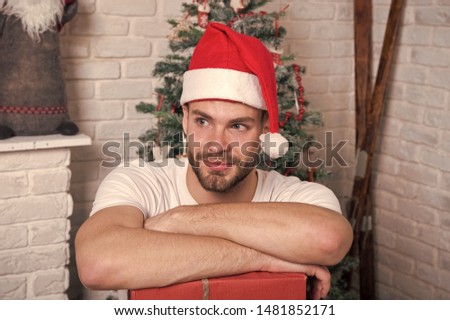 The morning before Xmas. happy santa man. delivery christmas gifts. online christmas shopping. New year scene with tree and gifts. man in santa hat hold christmas present. Christmas composition.