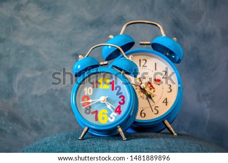 classic alarm clock on blue grainy rustic background