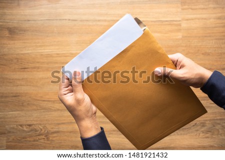 Male holding paper envelope, letter on floor wood. business concepts ideas