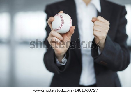 Cropped image of businesswoman holding baseball