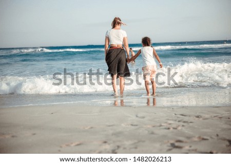 Happy family. Young beautiful mother and her daughter having fun on the beach. Positive human emotions, feelings, joy.
