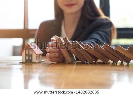 businesswoman hand stopping falling wooden dominoes effect business strategy concept