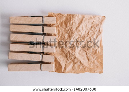 Woodenl clothespins, paper clip and brown sticker on white background. Isolated on white. View from above. Place for your text