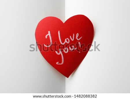 Paper heart with words I LOVE YOU on open notebook, top view